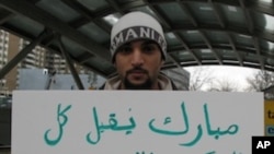 Saudi national Menyar al-Mufti displays an anti-Mubarak sign while in transit between two Washington protests, one at the Egyptian embassy and the other at the White House.