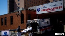 Paramedics wheel a patient from an ambulance to an emergency arrival area at Elmhurst Hospital during the outbreak of the coronavirus disease (COVID-19) in the Queens borough of New York City, New York, April 6, 2020. 