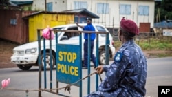 Police guard a roadblock as Sierra Leone government enforces a three day lock down on movement of all people in an attempt to fight the Ebola virus in Freetown, Sierra Leone, Sept. 19, 2014. 