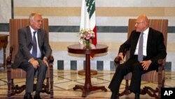In this photo released by Lebanon's official government photographer Dalati Nohra, Lebanese Prime Minister Tammam Salam, right, meets with French Foreign Minister Jean-Marc Ayrault at the government House, in Beirut, Lebanon, July 12, 2016. 