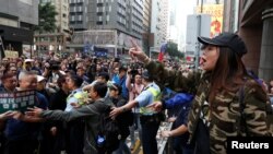 Seorang demonstran pro-China (kanan) yang melawan kemerdekaan Hong Kong berargumen dengan para demonstran pro-demokrasi di Hong Kong (1/1). (Reuters/Bobby Yip)