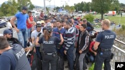 La police encadre des réfugiés à Salzburg à la frontière entre l’Autriche et l’Allemagne, 17 septembre 2015.