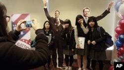 7일 서울 주재 미국대사관에서 열린 미 대선 개표 관전행사에서 바락 오바마 대통령과 미트 롬니 공화당 후보의 종이 인형과 함께 사진을 찍는 학생들.
