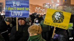 FILE - Demonstrators hold banners depicting the head of the ruling Social Democratic Party, Liviu Dragnea, during an anti-government protest in Bucharest, Romania, Feb. 11, 2017. 