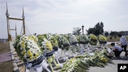 Cambodia University students lay down flowers during a memorial service near a bridge where festival goers were killed Monday in a stampede in Phnom Penh, Nov. 25, 2010. 