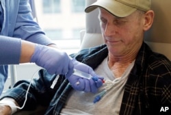 FILE - A lymphoma patient receives cellular immunotherapy as part of a study at the Fred Hutchinson Cancer Research Center in Seattle, Washington, March 21, 2017.