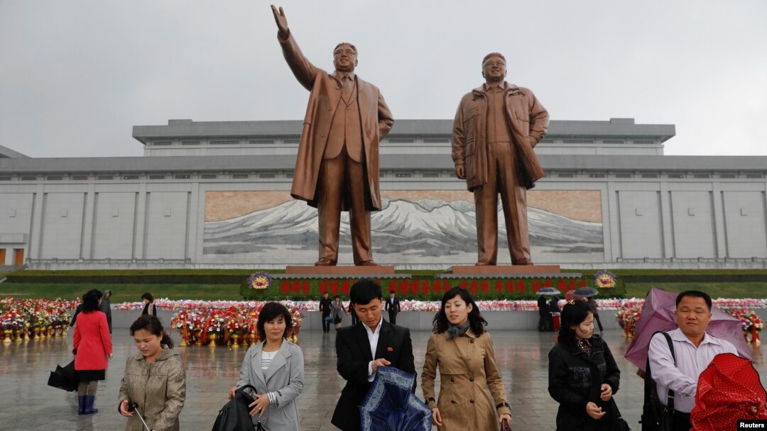 Warga Korea Utara usai memberikan penghormatan kepada patung Kim Il Sung (kiri) dan Kim Jong Il di Pyongyang, Jumat (14/4). Korut siap melakukan percobaan nuklir bawah tanah untuk memperingati HUT Kim Il Sung.