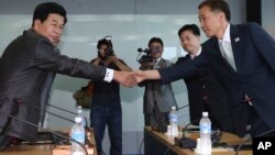 Kim Kiwoong, right, the head of South Korea's working-level delegation, shakes hands with his North Korean counterpart Park Chol Su, left, before their meeting at Kaesong Industrial District Management Committee in Kaesong, North Korea, August 14, 2013.