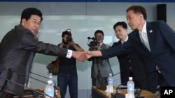 Kim Kiwoong, right, the head of South Korea's working-level delegation, shakes hands with his North Korean counterpart Park Chol Su, left, before their meeting at Kaesong Industrial District Management Committee in Kaesong, North Korea, August 14, 2013.