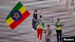 Baadhi ya wachezaji wa Ethiopia na bendera ya nchi yao katika gwaride la Olimpik Japan 2020