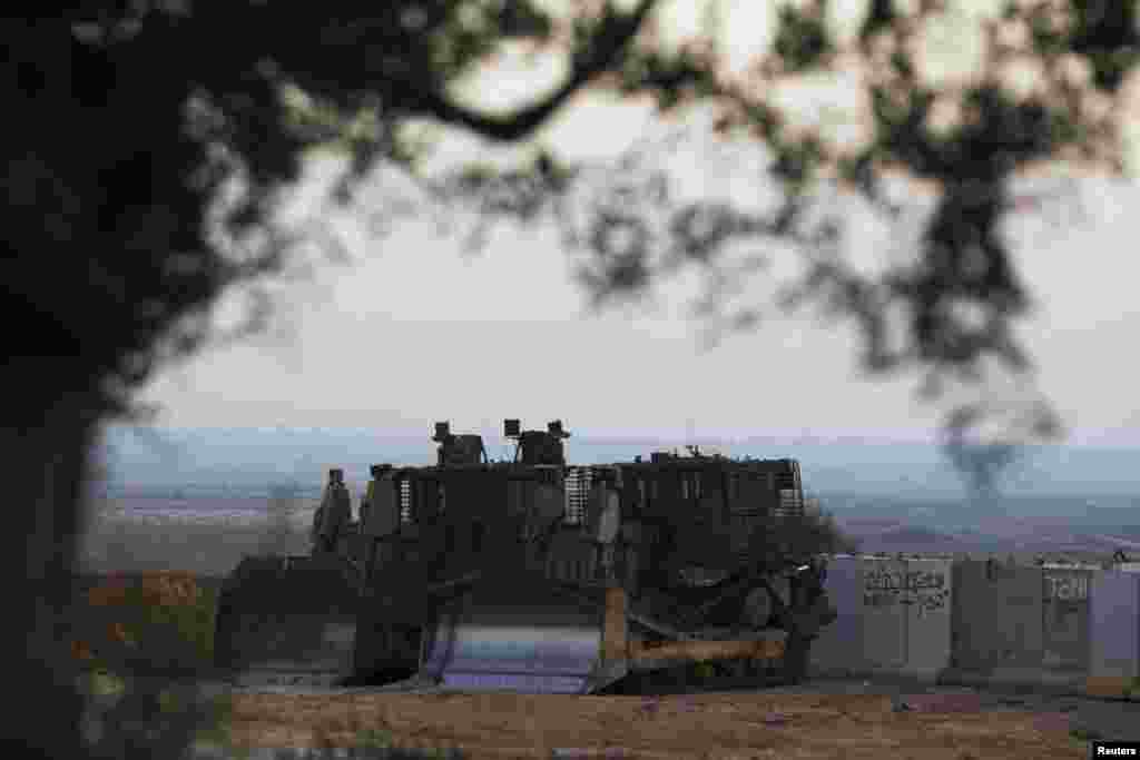 Israeli military bulldozers are seen near the Israeli border with northern Gaza Strip July 3, 2014.
