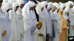 A Muslim boy prays during Eid al-Fitr prayer that marks the end of the holy fasting month of Ramadan in Jakarta, Indonesia, Aug. 30, 2011.