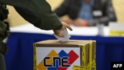 A member of the Bolivarian National Guard casts his vote at a polling station during regional and municpal elections in Fuerte Tiuna in Caracas, on Nov. 21, 2021.