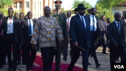 South Sudanese President Salva Kiir (R) and First Vice President Riek Machar (L) walk together at the presidential palace in Juba on April 26, 2016. (J. Patinkin/VOA)
