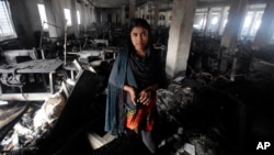 Cô thợ may Laiju đứng trong xưởng may Smart Export Garment Ltd đã bị hư hại sau trận cháy 