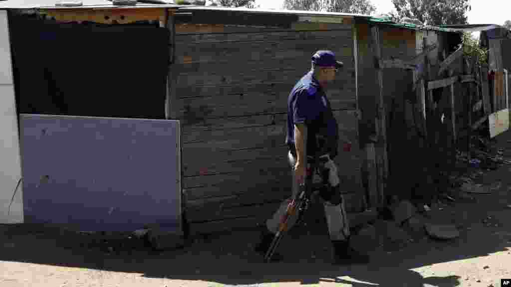 Un policier se promène entre les cabanes dans un bidonville à Germiston, à l&#39;est de Johannesburg, Afrique du Sud, jeudi 16 avril 2015.