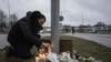 A man lights candles at a makeshift vigil in Orebro, Sweden, on Feb. 5, 2025 after a shooting at the adult education center Campus Risbergska school, where 11 people were killed.