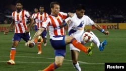 FILE - Diego Fernando Nadaya (R) of Mumbai City FC fights for the ball with Jose Miguel Gonzalez Rey (2nd R) of Atletico de Kolkata during the opening match of the Indian Super League soccer tournament at Salt Lake stadium in Kolkata, Oct. 12, 2014. 