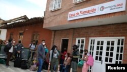 People line up in front of the formation house of the Zijin mine in Buritica, Colombia, on April 19, 2021. REUTERS/Luisa Gonzalez