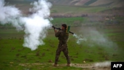 FILE - An Afghan National Army (ANA) soldier fires a rocket-propelled grenade (RPG) during a military operation in Badghis Province.