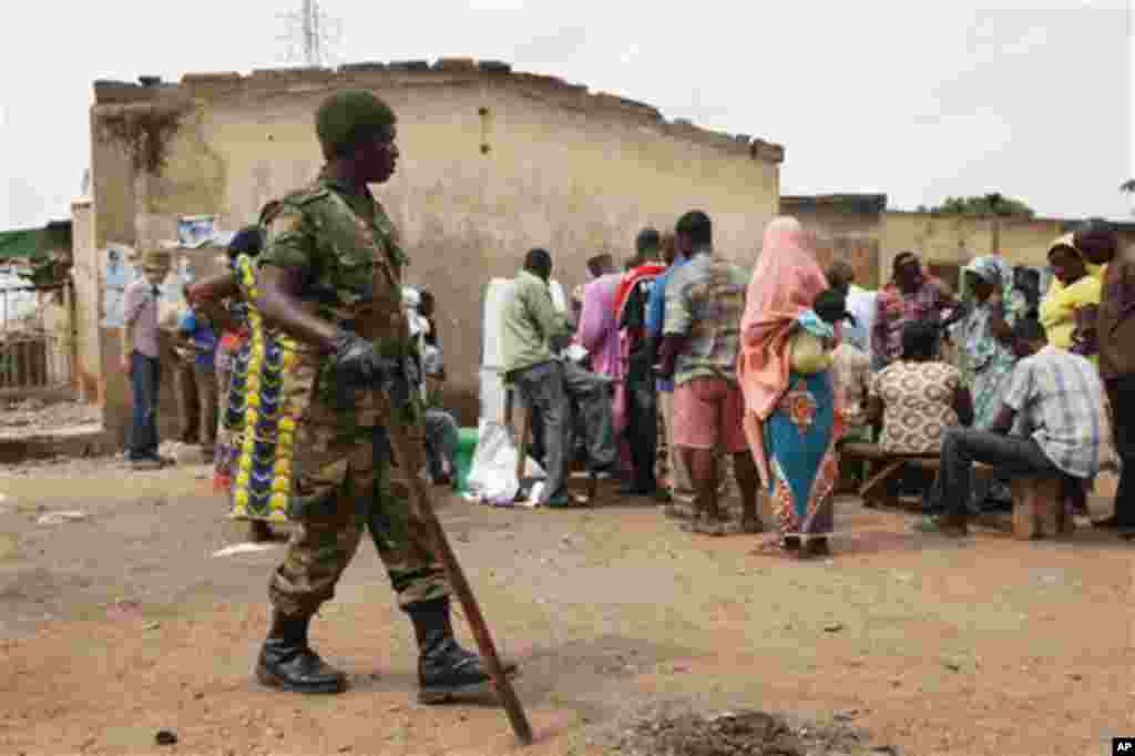 A Soldier stand guard as voters cast their vote during the gubernatorial election in Kaduna, Nigeria, Thursday, April 28, 2011. Two states in Nigeria's Muslim north voted Thursday for state gubernatorial candidates after their polls were delayed by viol