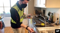 FILE - In this photo provided by climate scientist Rob Jackson, researcher Eric Lebel samples natural gas from a stove in Stanford, Calif., in 2021.