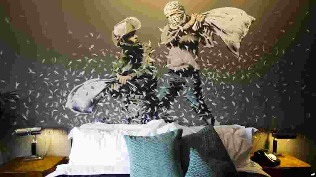 គំនូរនៅលើជញ្ជាំងរបស់លោក Banksy បង្ហាញឲ្យឃើញប៉ូលិសការពារព្រំដែនអ៊ីស្រាអែលម្នាក់ និងជនជាតិប៉ាឡេស្ទីន វាយគ្នាដោយប្រើខ្នើយក្នុងបន្ទប់ «សណ្ឋាគារដែលខ័នដោយជញ្ជាំង» នៅទីក្រុង Bethlehem នៃតំបន់ West Bank។