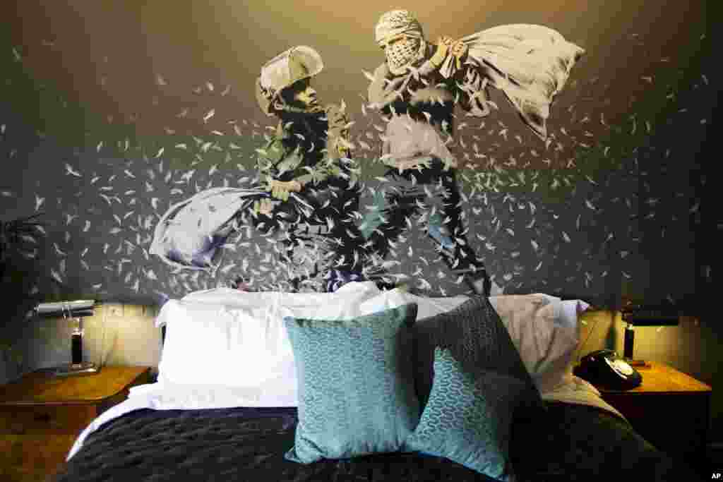 A Banksy wall painting showing Israeli border policeman and Palestinian in a pillow fight is seen in one of the rooms of the &quot;The Walled Off Hotel&quot; in the West Bank city of Bethlehem. The nine-room guest house opened its doors to media, showcasing its unique &quot;worst view in the world.&quot;