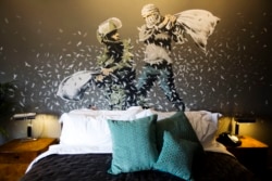 A Banksy wall painting showing Israeli border policeman and Palestinian in a pillow fight is seen in one of the rooms of the "The Walled Off Hotel" in the West Bank city of Bethlehem, March 3, 2017.