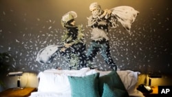 A Banksy wall painting showing Israeli border policeman and Palestinian in a pillow fight is seen in one of the rooms of the "The Walled Off Hotel" in the West Bank city of Bethlehem, March 3, 2017. 