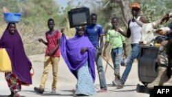 Des réfugiés fuyant la localité nigériane de Malam Fatori, près des frontières du Nigeria avec le Niger et le Tchad,passent devant une patrouille de soldats nigériens pour se rendre à Bosso, au Niger, le 25 mai 2015.