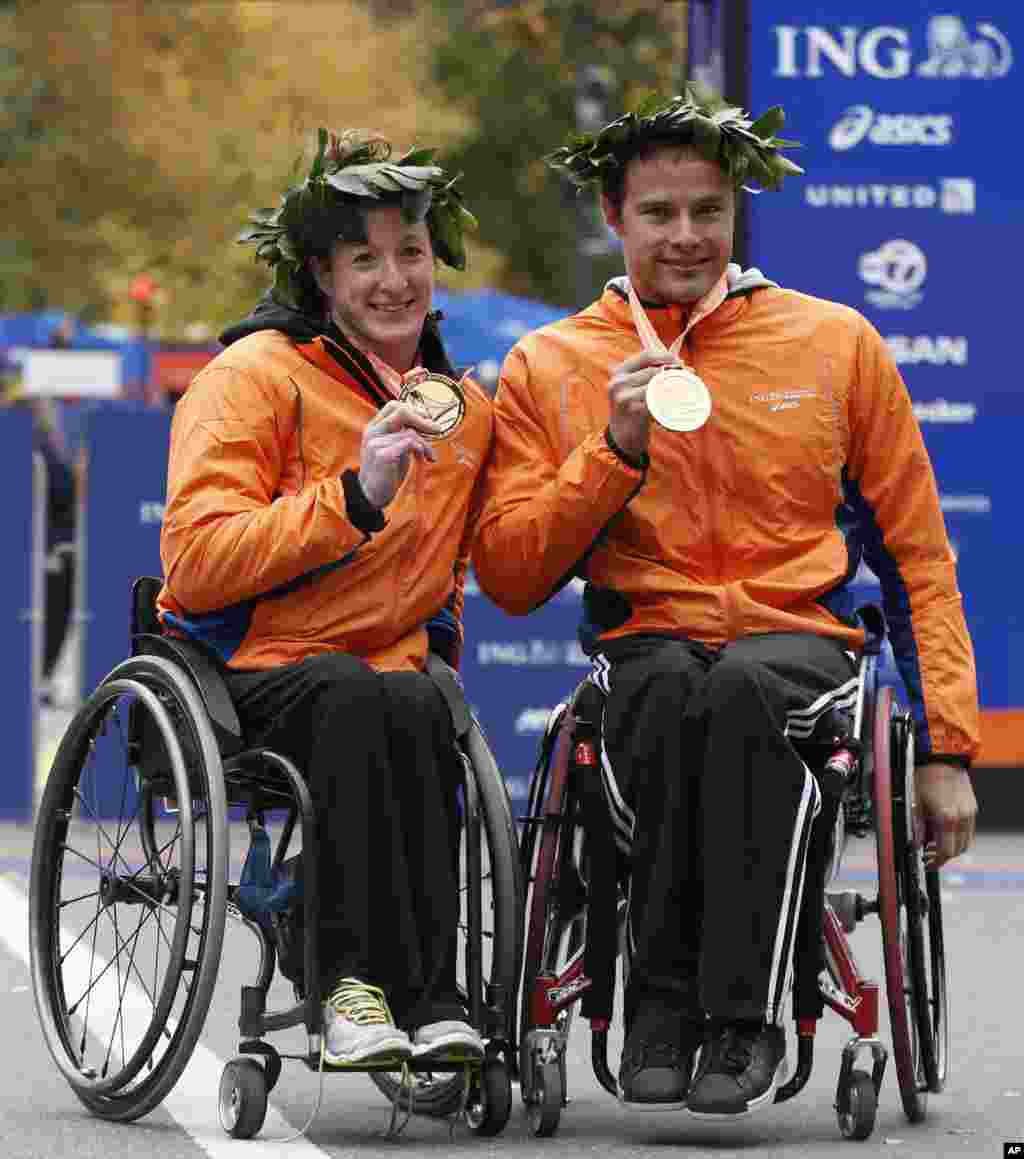 Women's wheelchair winner Tatyana McFadden of Maryland, left, and men's wheelchair winner Marcel Hug of Switzerland pose for photographers after winning their divisions in the New York City Marathon, Nov. 3, 2013, in New York.