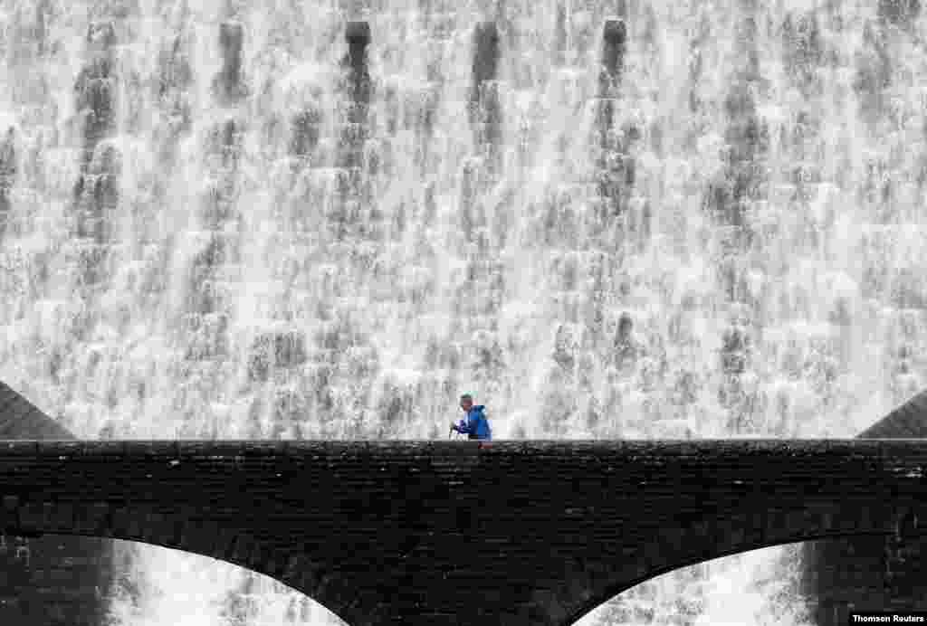 영국 웨일즈의 엘란 밸리의 댐 앞 다리를 한 남성이 건너고 있다. 