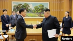 Severnokorejski lider Kim Džong Un se pozdravlja sa Čung Eui Jongom, šefom južnokorejske predsedničke Kancelarije za nacionalnu bezbednost u Pjongajngu, 6. marta 2018. 