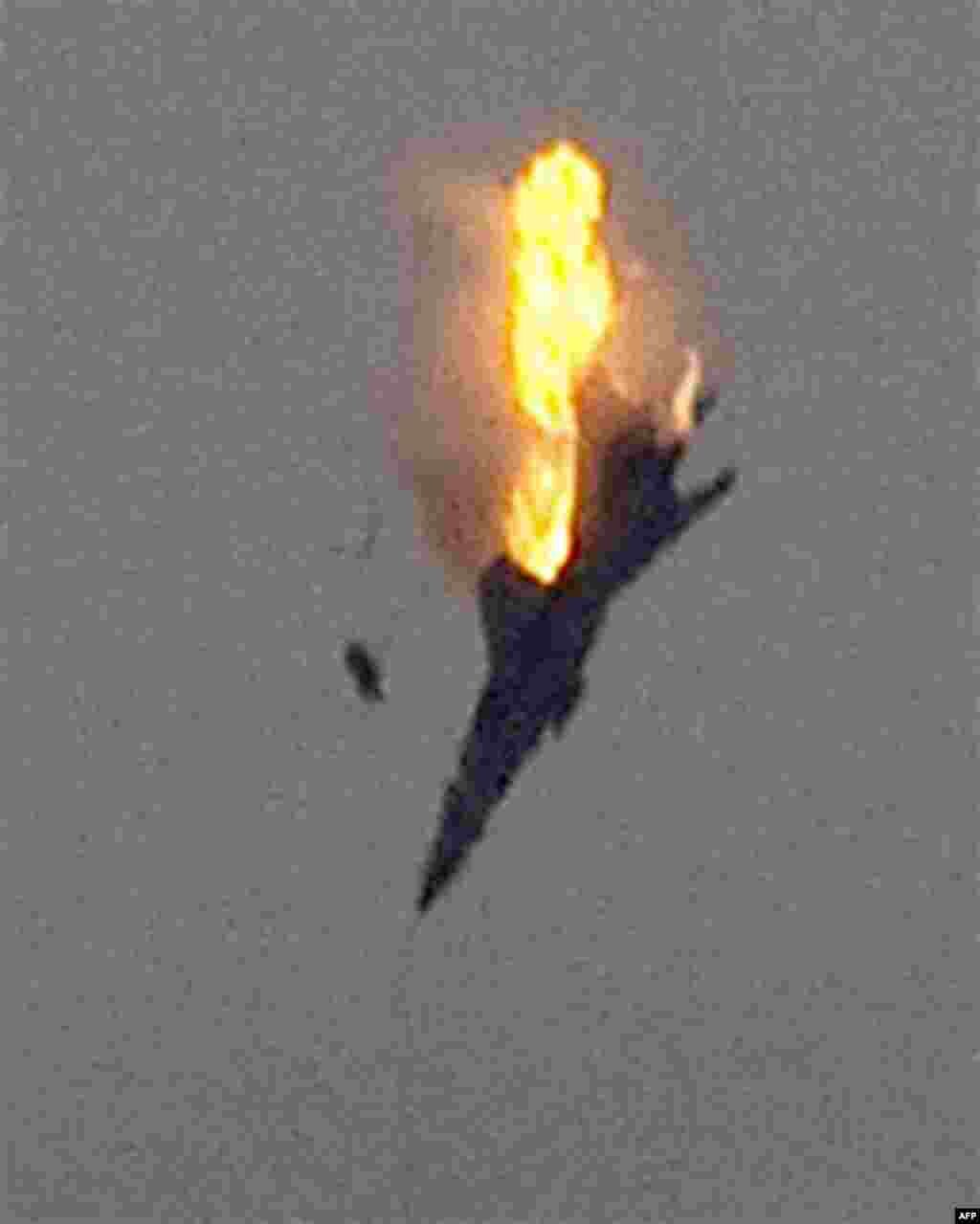 An object, thought to be the pilot, ejects from the cockpit of a doomed warplane after it was shot down over the outskirts of Benghazi, eastern Libya, Saturday, March 19, 2011. Explosions shook the Libyan city of Benghazi early on Saturday while a fighte