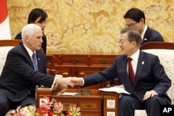 U.S. Vice President Mike Pence, left, shakes hands with South Korean President Moon Jae-in during their meeting at the presidential office Blue House in Seoul, Feb. 8, 2018.