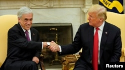 U.S. President Donald Trump, right, shakes hands with Chilean President Sebastian Pinera in the Oval Office of the White House in Washington, Sept. 28, 2018. 