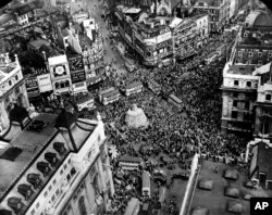 A crowd gathers to celebrate V-E Day at Piccadilly Circus in London, England, May 8, 1945.