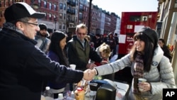 Felice Vazquez greets a neighbor as she mans a table providing hot drinks and snacks on Washington Street as the buildings around them remain without power due to damage caused by Superstorm Sandy in Hoboken, New Jersey, November 4, 2012.