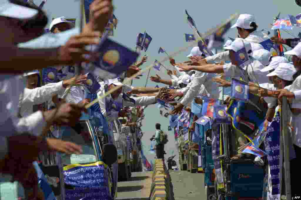Cambodian supporters of Cambodia National Rescue Party (CNRP) wave during the general election campaign in Phnom Penh.