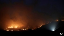 A wildfire threatening property glows on the hills south of the Australian capital, Canberra, Jan. 31, 2020. The blaze on Canberra's southern fringe has razed more than 21,500 hectares (53,000 acres) since it was sparked Monday.