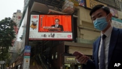 A TV screen broadcasts the news of the opening session of China's National People's Congress in Hong Kong, March 5, 2021, that will also elect some members of the city's legislature, as part of Beijing's planned revamp of Hong Kong's electoral system.