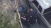 This aerial image made from a helicopter video provided by WHDH shows several officers allegedly pummeling Richard Simone, who had exited his vehicle after a high-speed police pursuit, in Nashua, New Hampshire, May 11, 2016.