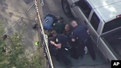 This aerial image made from a helicopter video provided by WHDH shows several officers allegedly pummeling Richard Simone, who had exited his vehicle after a high-speed police pursuit, in Nashua, New Hampshire, May 11, 2016.