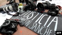 Para jurnalis meletakkan kamera, perekam video, dan mikrofon sebagai tindakan protes menuntut keadilan atas pembunuhan wartawan Meksiko Luis Martin Sanchez Iniguez di Guadalajara, Meksiko, 8 Juli 2023. (Foto: AFP)