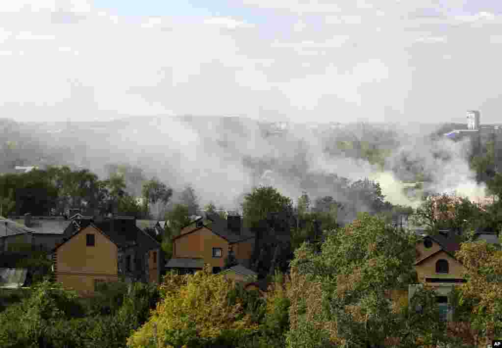 Smoke rises over a residential neighborhood near the airport after shelling in Donetsk, eastern Ukraine, Oct. 1, 2014.