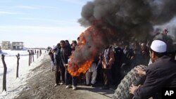 Afghans burn tires during an anti-U.S. demonstration over burning of Qurans at a US military base, in Muhammad Agha, Logar province south of Kabul, Afghanistan, February 25, 2012.