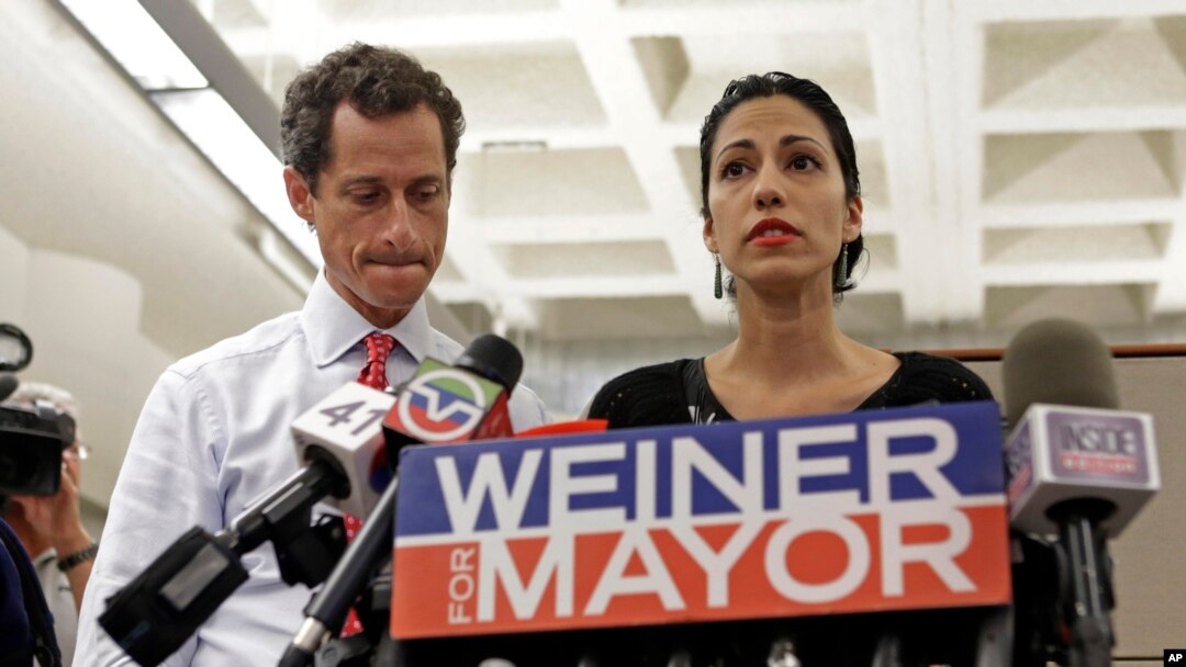 New York mayoral candidate Anthony Weiner, left, listens as his wife, Huma Abedin, speaks during a news conference at the Gay Men's Health Crisis headquarters, July 23, 2013, in New York. 
