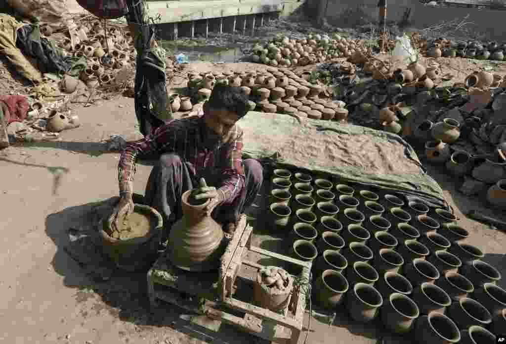رستم علی مشغول ساختن گلدان در کارگاه خود در کراچی، پاکستان