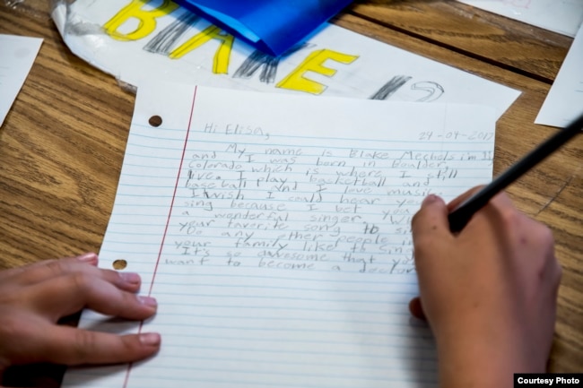 A student, Blake Mechels, writes a letter to student Elisa, of Dadaab Refugee Camp. Fifth graders at Valley Peaks Elementary School participate in a Letters of Hope project in Boulder, Colorado. (Carey Wagner/CARE)